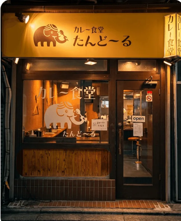 夜のたんどーるの外観。黄色い象の看板と木の扉